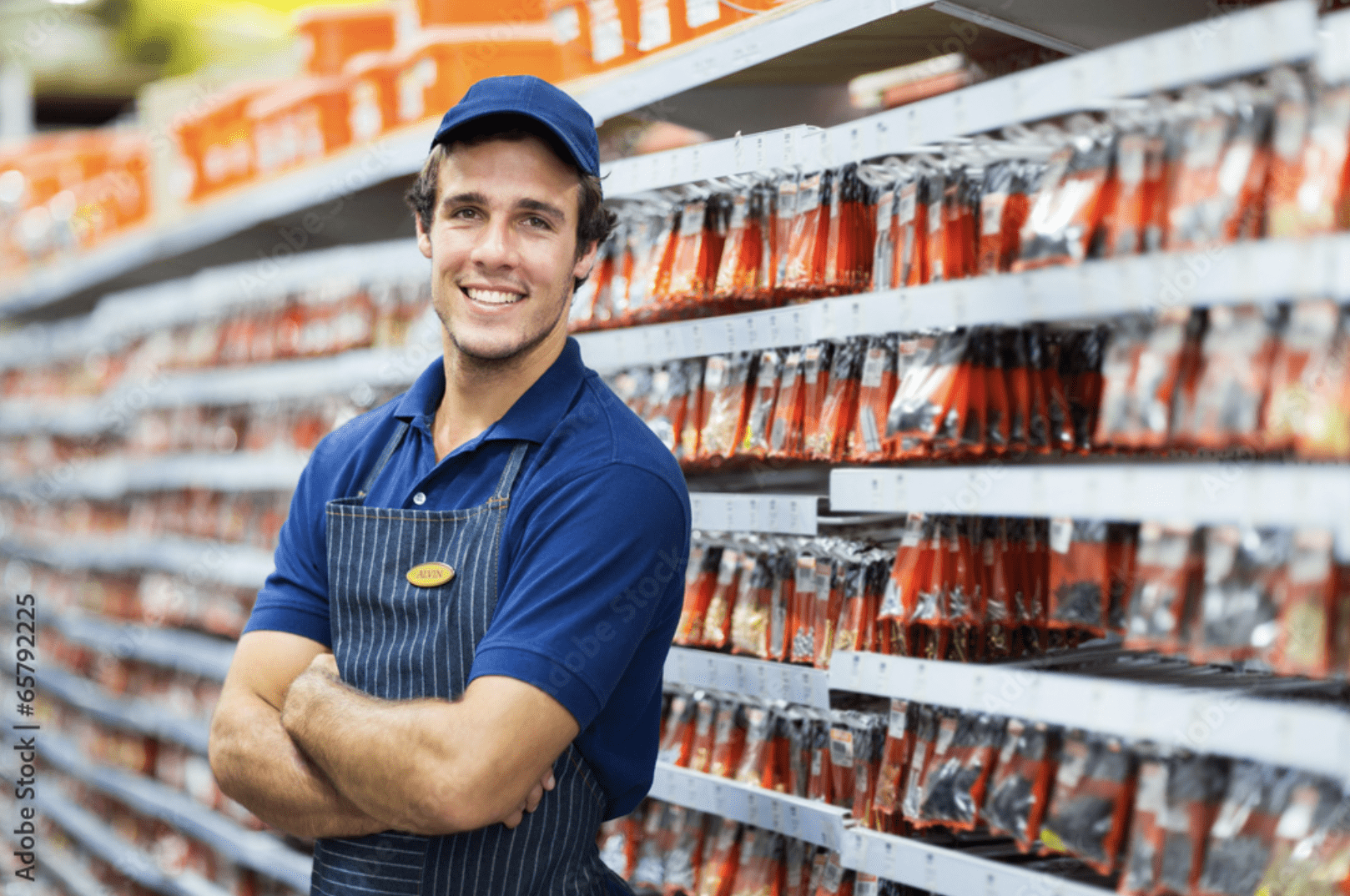 Worker in a hardware store standing next to hardware pieces in plastic bags